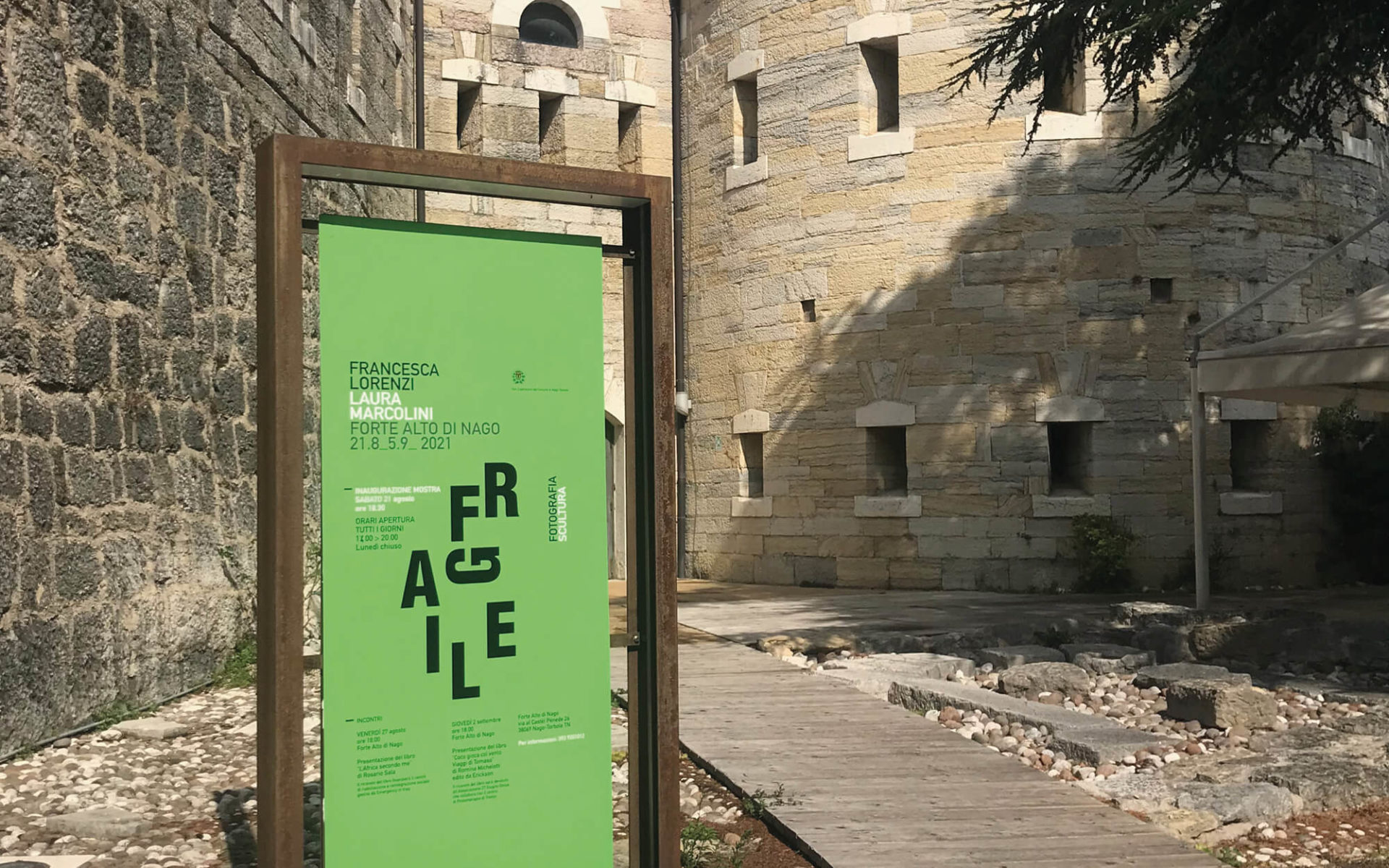 veduta frontale del cartello invito mostra di arte al forte alto di nago. Progetto di coordinamento immagine diadestudio arco - trento - rovereto - riva del garda